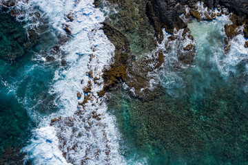 Drone photo of waves crashing against rocks in Hawaii - obrazy, fototapety, plakaty