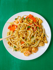 Above-view of Chinese seafood noodles and chopsticks