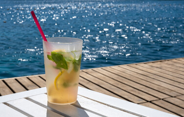 cold drink standing on wooden floor by the beach