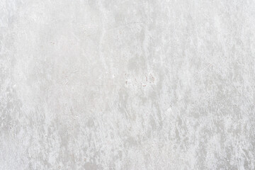 Old light gray wall close-up, peeling plaster. Cracks on surface. Vintage background