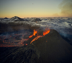Scenic view of volcano erupting at sunset
