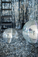 A mirror ball in a room decorated with silver decor. 