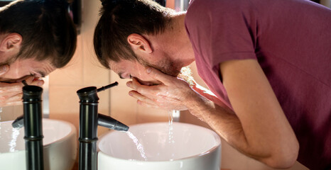 morning routine, young bearded male person washing up the face