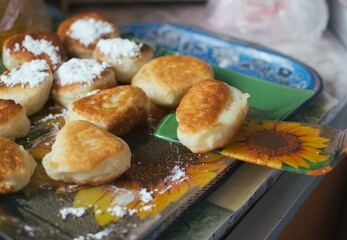 Putting a spatula of ready-made fried donuts on a platter