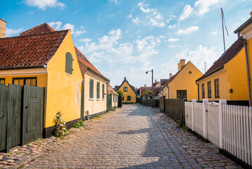 Fototapeta na wymiar Beautiful and charming medieval old town centre of the medieval Danish village. Cozy yellow buildings.