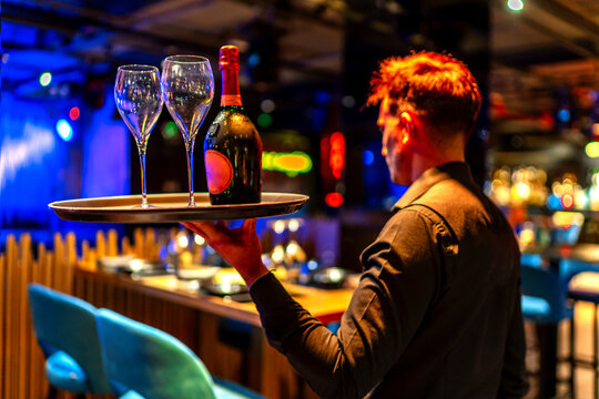 waiter serving a bottle of champagne