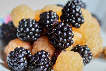 A plate of ripe blackberry with juicy white raspberry