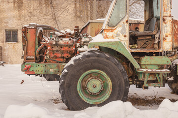Fototapeta na wymiar old rusty abandoned tractors in snowy winter