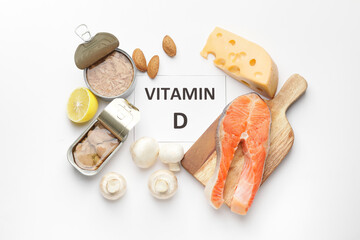 Text VITAMIN D and different tasty products on white background