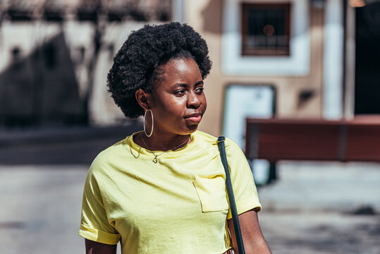 Portrait of Black Afro-American girl walking down a street in the old town.