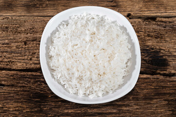 Rice in bowl isolated on wood