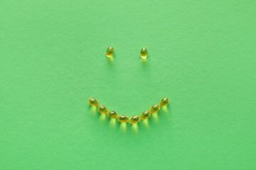 Smile made of pills on color background