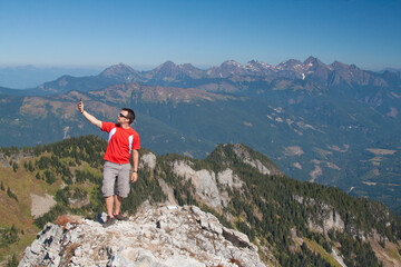 Man looks for phone connection while hiking in the mountains.