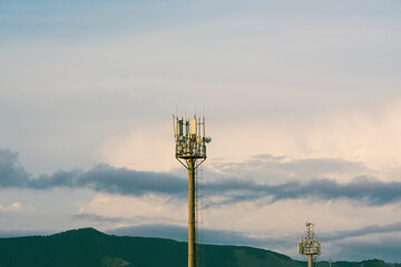 the transmitting antenna of cellular communication on the background of mountains and the sky.