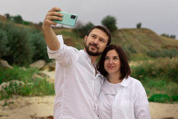 young man takes a selfie with his lover outsides