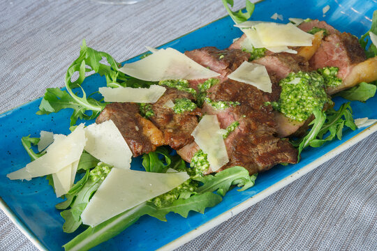 Sliced beef simmenthal aged 40 days with rocket and parmesan with demi glace sauce.
 Tagliata di manzo razza simmenthal frollata 40 giorni rucola e grana con salsa demi glace