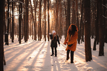 Happy female friends playing with snow in park during winter