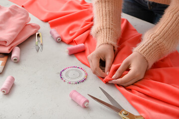 Young woman sewing clothes in studio