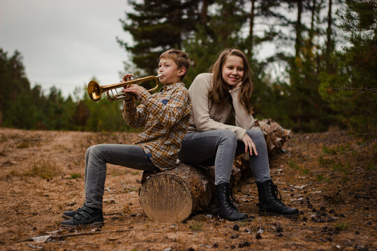 Boy and girl, brother and sister, teenagers play the trumpet and violi