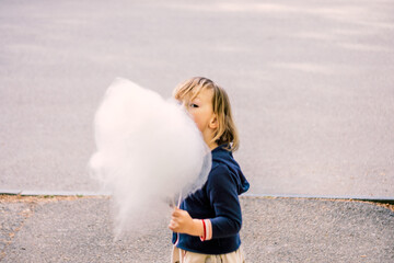 Cute young girl 3-4 years old eating cotton candy