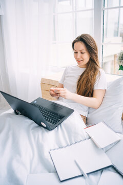 girl working on a laptop in bed