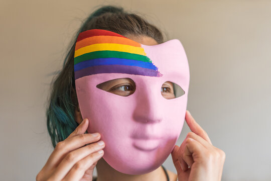 Woman preparing for pride day with handmade mask with LGBTI flag