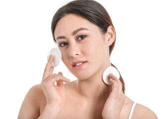 Beautiful young Asian woman with cotton pads on white background