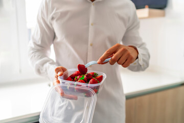 executive sipping healthy fruit in his tupperware