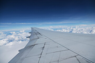 Fototapeta na wymiar Airplane window with the sky and white clouds
