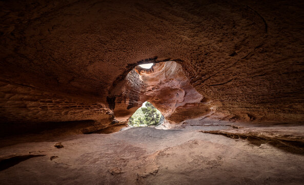 Image of a cave with a large entrance and a hole or window at the top