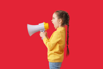 Little girl shouting into megaphone on color background