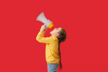 Little girl shouting into megaphone on color background
