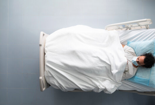 Young man lying asleep on a hospital bed. overhead photo.