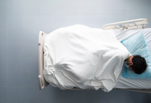 Young Man Lying Asleep On A Hospital Bed. Overhead Photo.