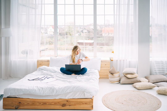 Blonde Girl Working On Laptop In Bed