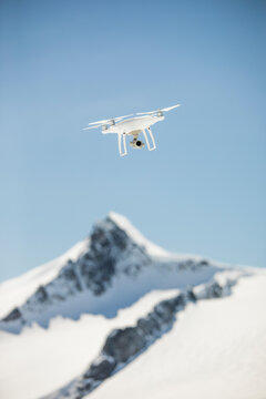 Drone flies in mid-air above a mountain summit, British Columbia.