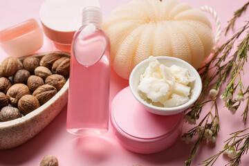 Bowl of shea butter and bath supplies on color background, closeup