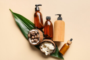 Coconut shell with shea butter, nuts and cosmetic products on color background