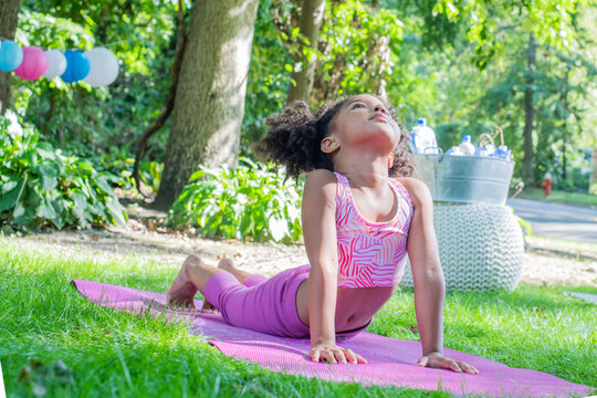 Young girl practicing yoga in backyard