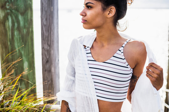 Young Woman in swimsuit with sun shirt on outdoor deck