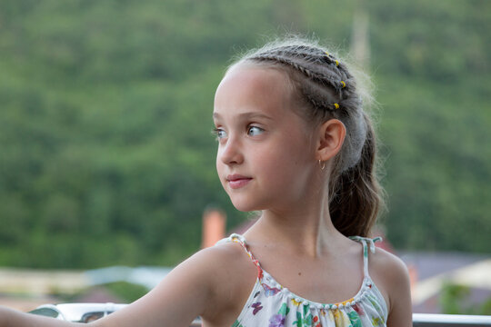 a girl in a sarafan looks away with a light smile