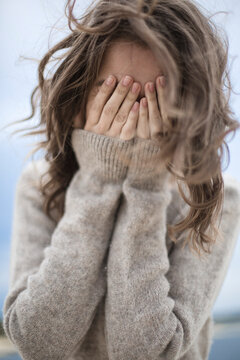 the girl laughs and covers her face with her hands, the wind develops