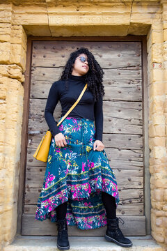France, medieval town of Roanne. Pretty young girl in blue and black dress walking down the street in the old town. Concept of travel and wanderlust. Spring