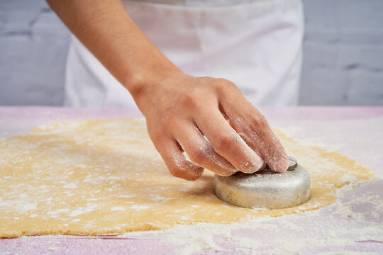 Cutting the cookies for the cornstarch alfajores with a mold.