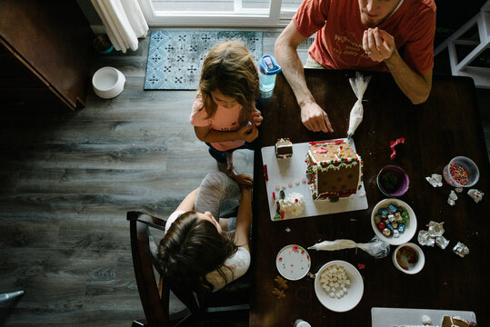 Family making gingerbread houses together at home