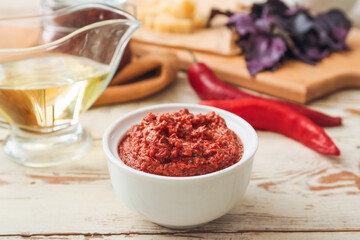 Bowl of tasty pesto sauce on wooden table