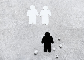 Paper human figures on light background. Concept of racism
