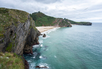 cliffs of Andrin beach in Llanes Asturias Spain, seaside scenery with turquoise waters, green...
