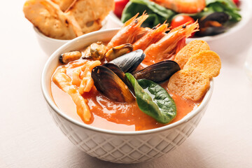 Bowl of tasty Cacciucco soup on table, closeup