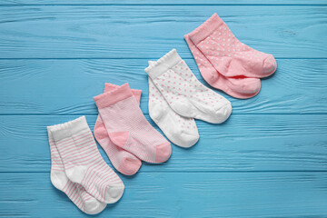 Baby socks on color wooden background